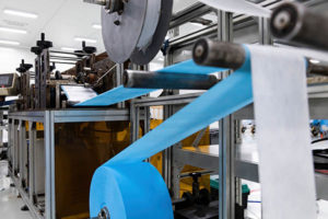 Industrial machine in action handling and converting web.