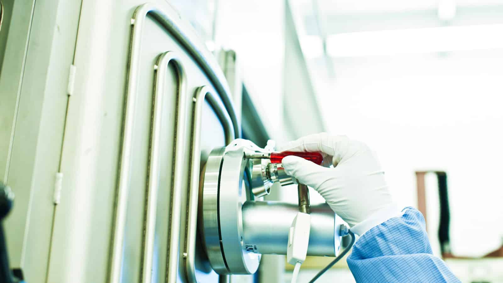 A hand working on a clean room asembly machine