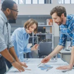 Group of three people at a table discussing plans