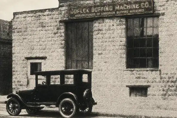 Historic Keller machine company building with an early automobile parked outside