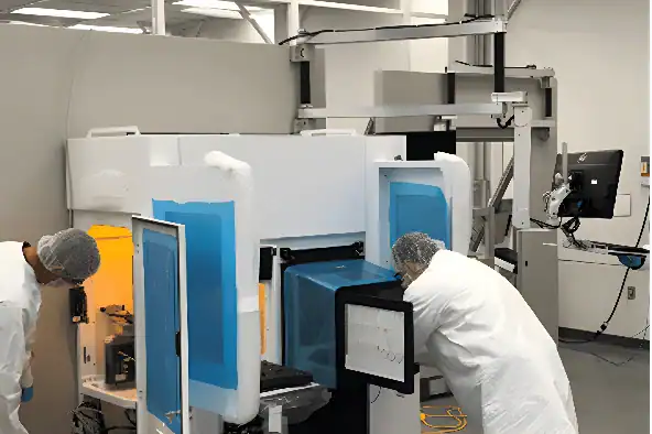 Technicians inspecting cleanroom manufacturing equipment during precision assembly and testing
